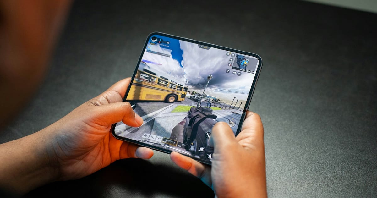 Una persona sostiene un celular plegable con un videojuego abierto en pantalla.
