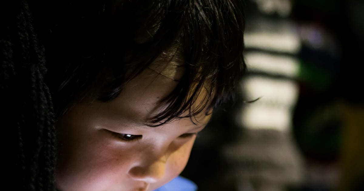Un niño pequeño mira la pantalla de una tableta.