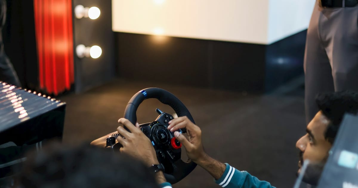 Un jugador con volante de carreras compite en un simulador de rally.