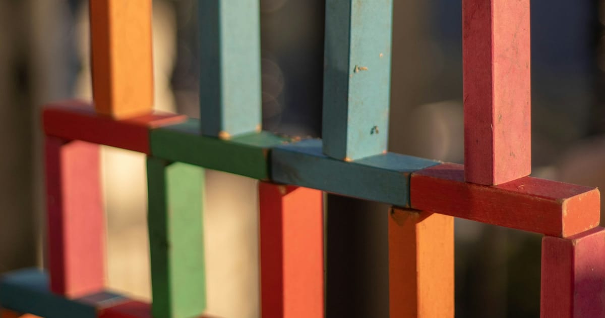Bloques de madera de colores apilados formando una construcción.